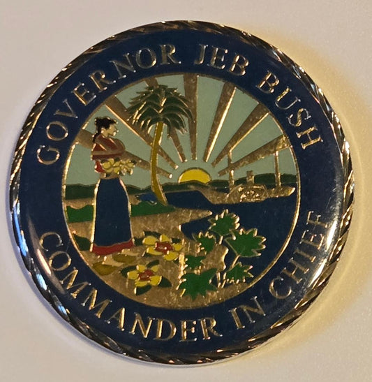Circular emblem with 'Governor Jeb Bush Commander in Chief' text and scenic design on a white background